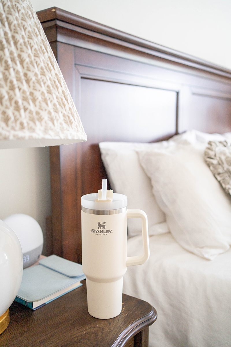 A cream Stanley 40 oz. Adventure Quencher Tumbler on a nightstand