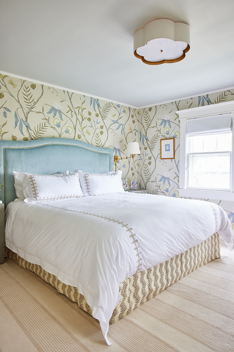 grandmillennial style bedroom for carly riordan by jennifer muirhead interiors featuring adam's eden wallpaper by lewis & wood, susan gordon pottery poppy picture frame, matouk truffle gordian knot bedding, visual comfort primitive swing arm, salisbury & manus sorin 3-drawer nighstand castor, annie selke la mirada wheat handwoven cotton rug, and susan gordon pottery hydrangea intalgio