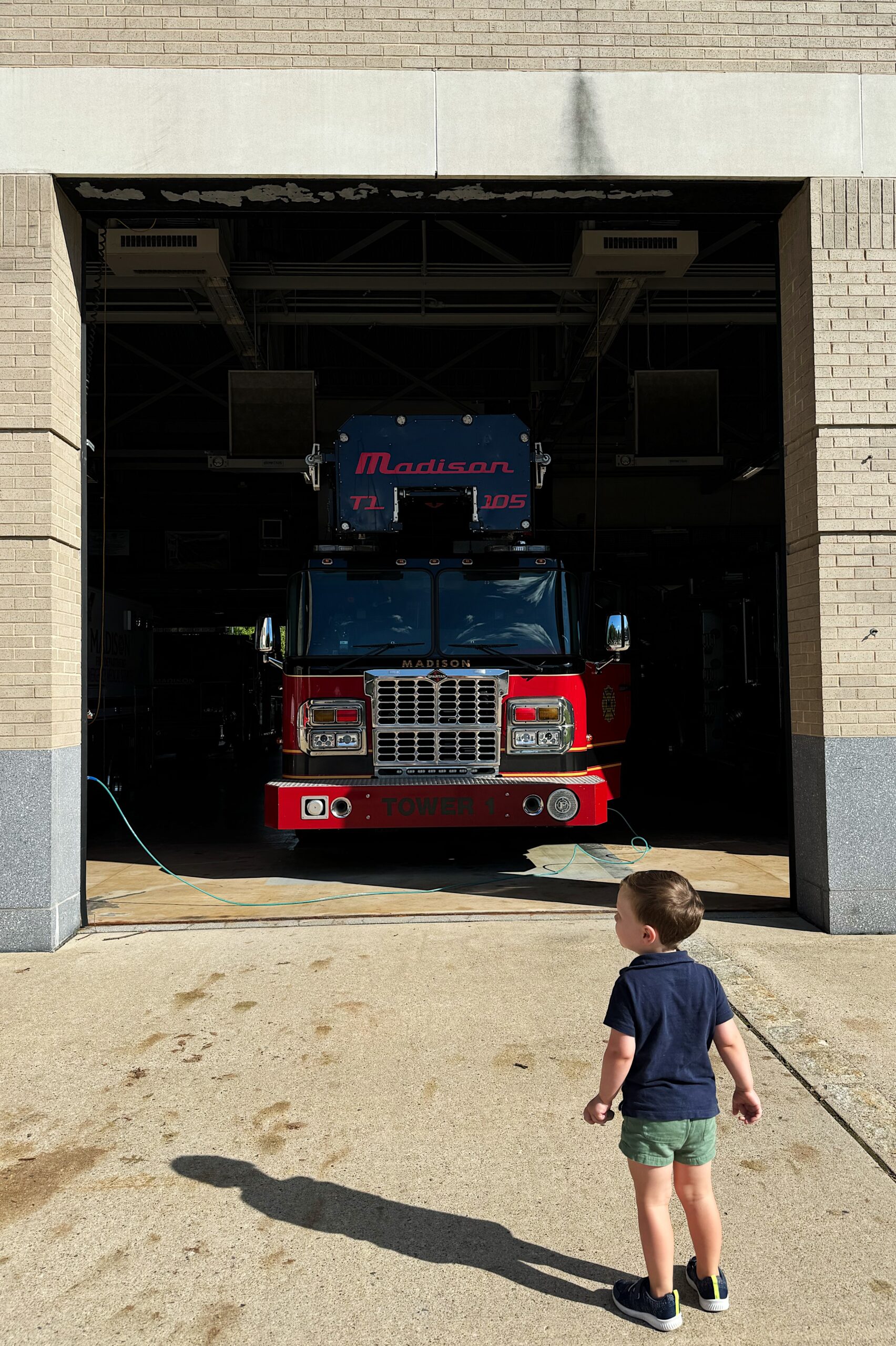 Jack standing outside of a firestation bay admiring the fire engine