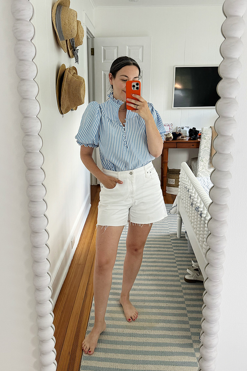 Carly wearing white denim shorts and Tuckernuck puff sleeve shirt