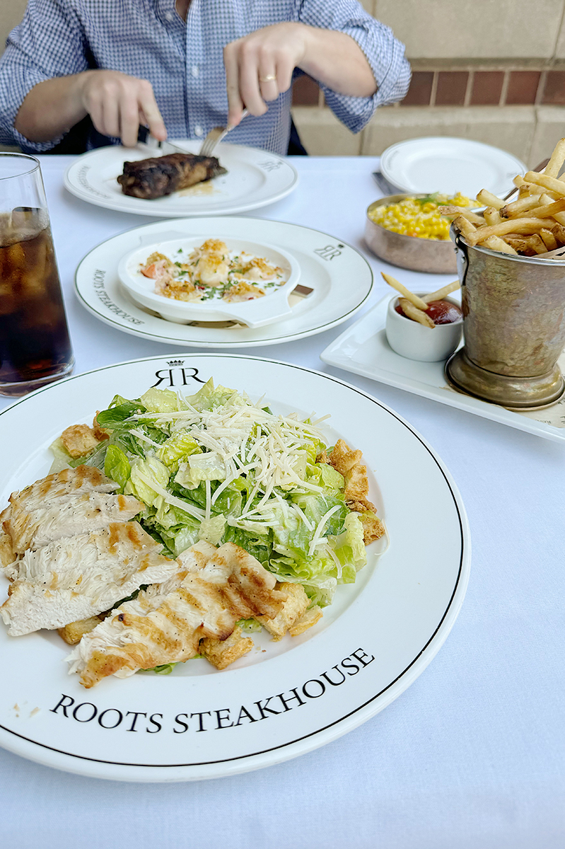 Girl lunch with chicken Cesar salad, french fries, and a diet coke 