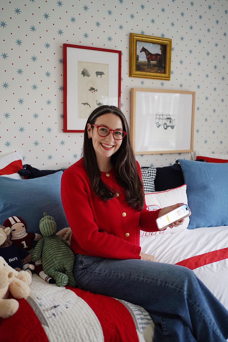 Carly sitting in her boys' room holding her phone with her Audible subscription 