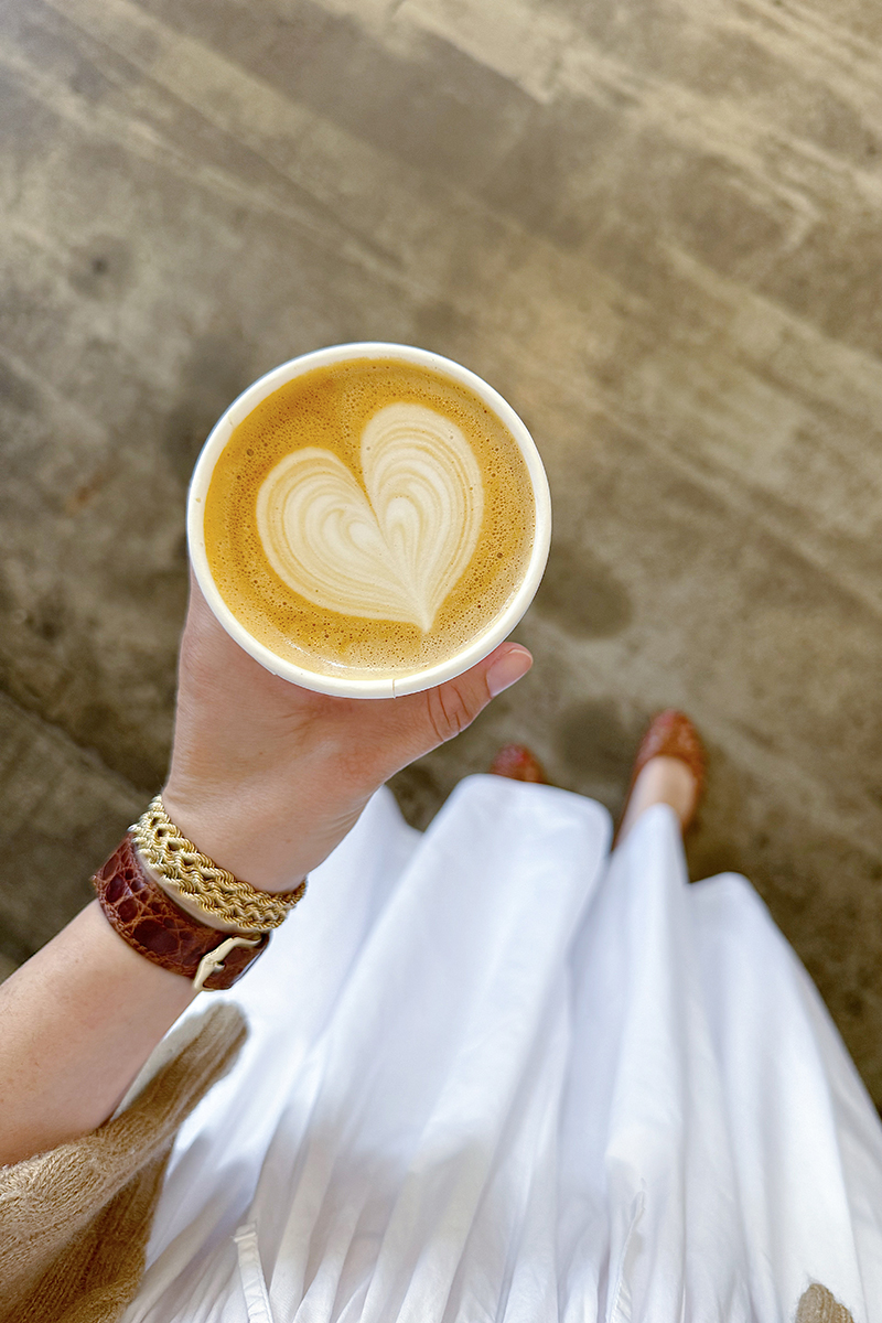 Carly holding a latte with a heart design