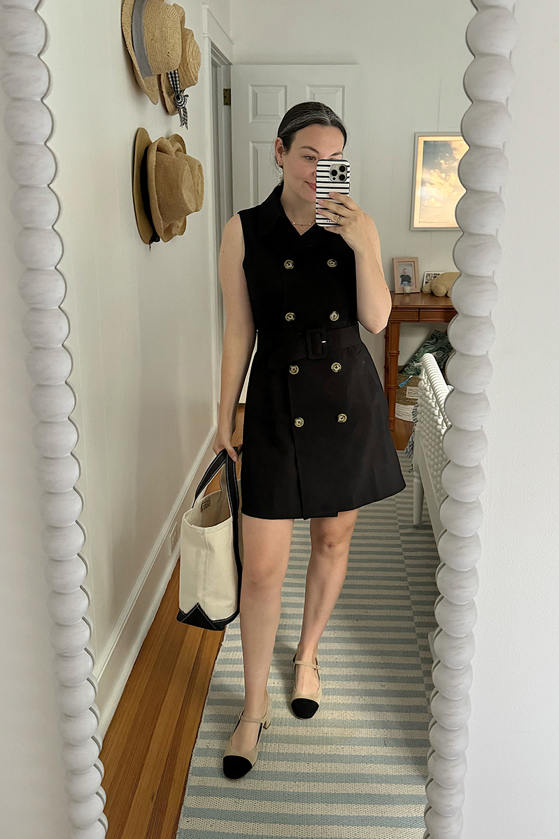 Carly Riordan taking a mirror selfie wearing a double breasted dress and cap toe flats. 