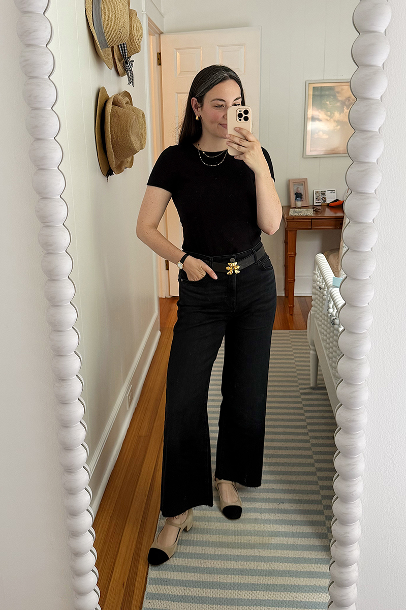 Carly in a mirror selfie wearing a black sweater and black jeans.