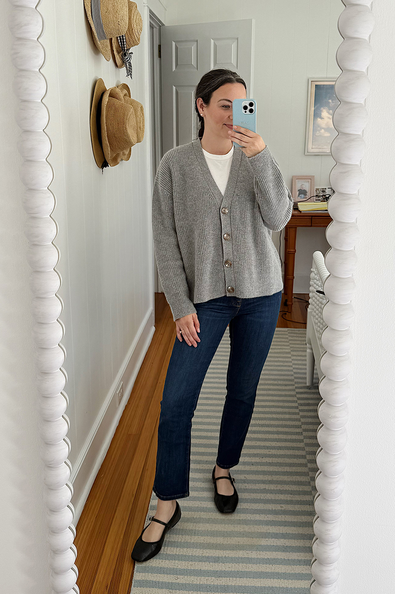 Carly Riordan in a mirror selfie wearing a grey sweater and mary janes.