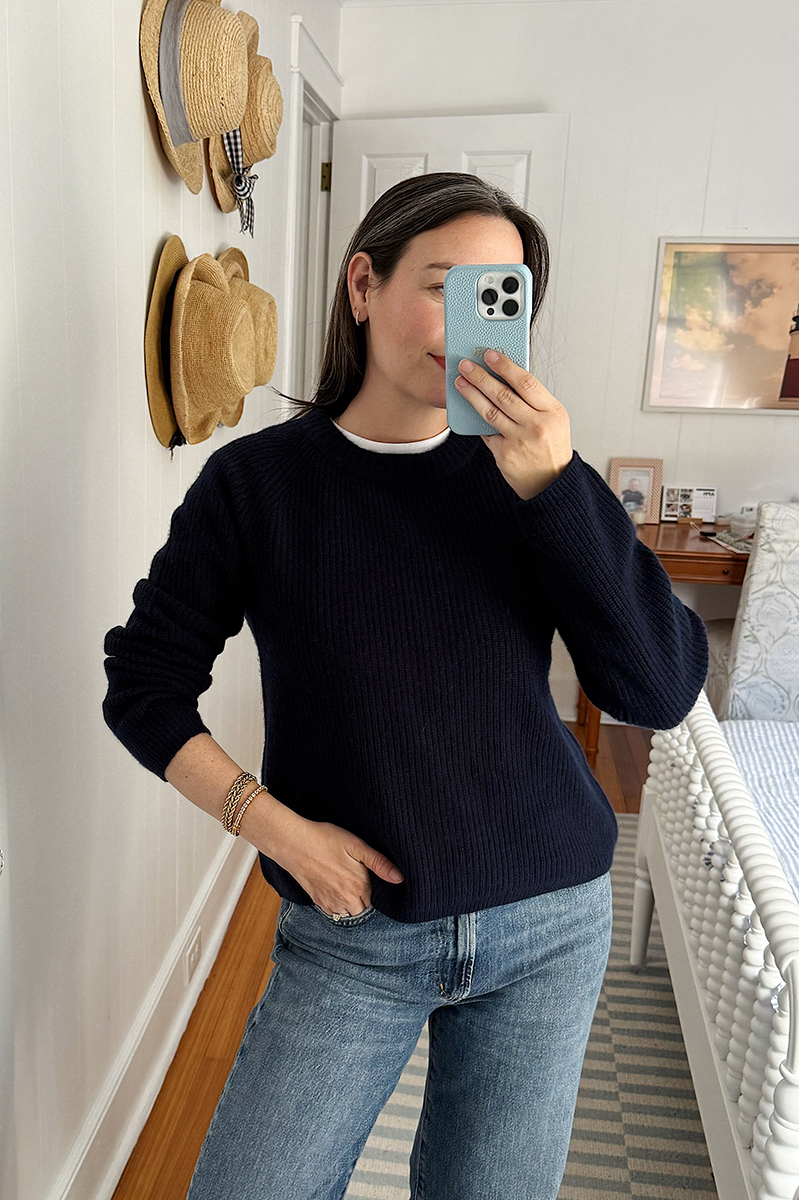 Carly Riordan wearing a Quince navy cotton crewneck sweater.