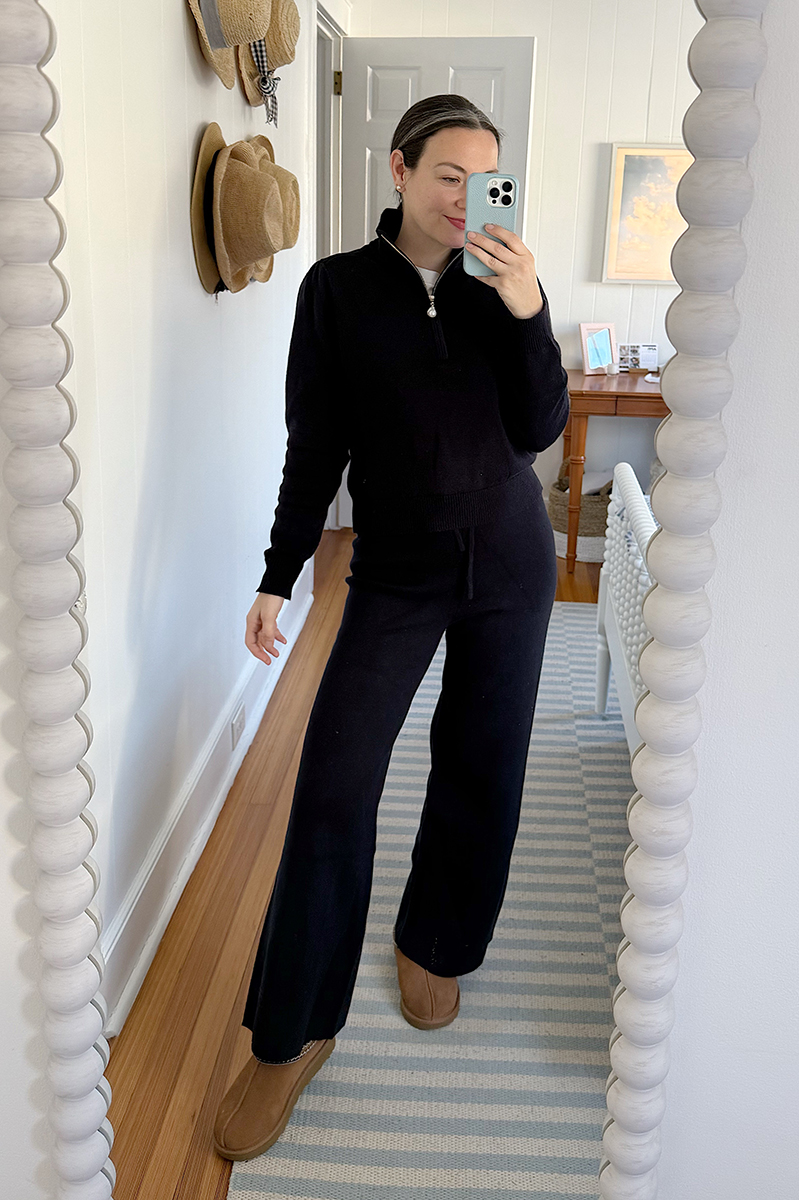 Carly Riordan taking a mirror selfie wearing a navy matching set.