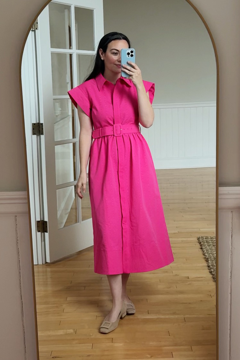 Carly Riordan taking a mirror selfie wearing a hot pink dress.